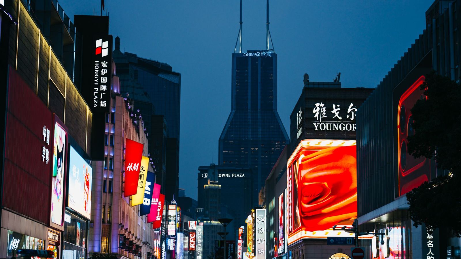 Digital advertising screens in a city at night — banner advertising for CBD and vape brands UK